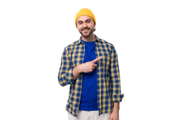 young caucasian brunette handsome man with a beard and mustache points his hand to the side on a white background with copy space