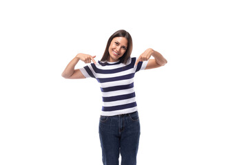 Obraz na płótnie Canvas energetic young caucasian brunette woman in a striped t-shirt rejoices on a white background with copy space. advertising concept