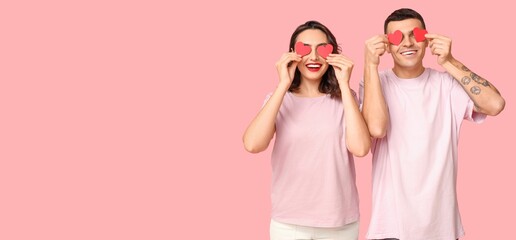Funny young couple with paper hearts on pink background with space for text. Valentine's Day...