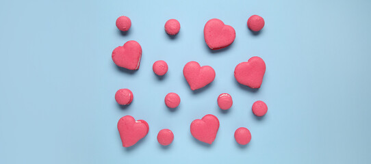 Many sweet macarons on light blue background, top view