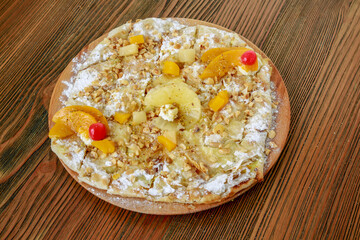 Fruit pie with pineapple and peach served in wooden board isolated on table side view of arabic food