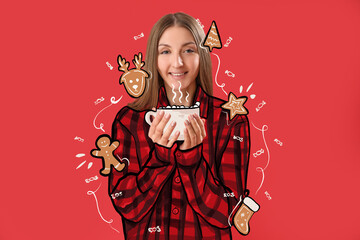 Young woman in pajamas, with cup of hot chocolate and drawn Christmas cookies on red background
