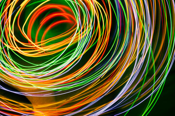 Abstract multi-colored light , swirl and curve of blue, green and red bright light tracks against a...
