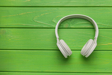 Modern white headphones on wooden background