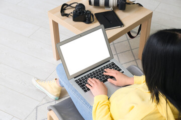Female photographer with laptop sitting on chair