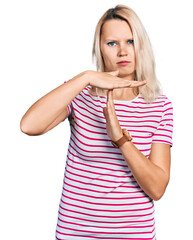Young caucasian woman wearing casual clothes doing time out gesture with hands, frustrated and...