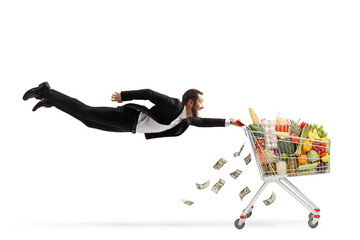 Businessman flying with a shopping cart and losing money, expensive food products concept