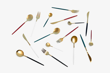 Golden set of cutlery with colorful handles on white background