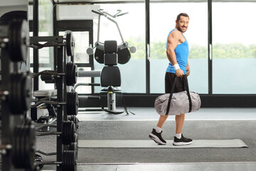 Fototapeta na wymiar Man with a sports bag walking in a gym
