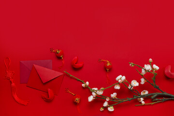 Composition with envelopes, fortune cookies and Chinese symbols on red background. New Year celebration