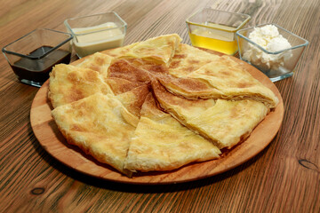 Unleavened bread with dip served in wooden board isolated on table side view of arabic food
