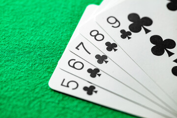 Combinations of cards in poker, straight flush five cards of black cross suit from five to nine, selective focus