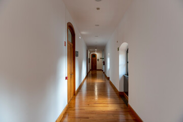 PASILLO BLANCO CON PUERTAS Y SUELO DE MADERA