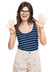 Young beautiful caucasian girl wearing casual clothes and glasses showing and pointing up with...