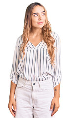 Fototapeta premium Young beautiful blonde woman wearing casual clothes looking away to side with smile on face, natural expression. laughing confident.