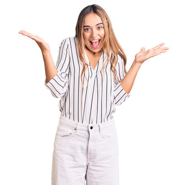 Young beautiful blonde woman wearing casual clothes celebrating victory with happy smile and winner expression with raised hands