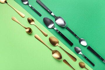 Different stylish spoons on color background