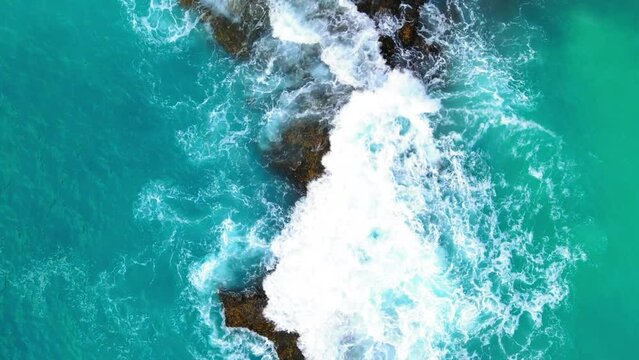 Aerial Lockdown Shot Of Beautiful Blue Water Of Sea Splashing On Rocks - Bali, Indonesia