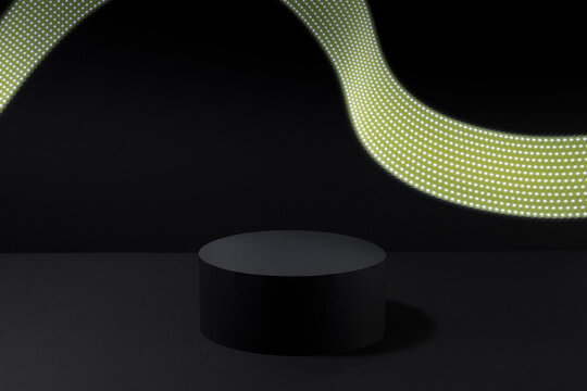 Abstract stage mockup with one black round podium with glowing neon yellow light flash as line in dynamic for presentation cosmetic products, goods on black background. Abstract scene in disco style.