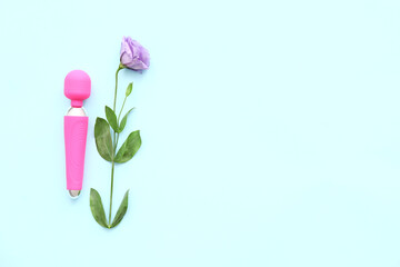 Pink vibrator from sex shop and beautiful eustoma flower on blue background