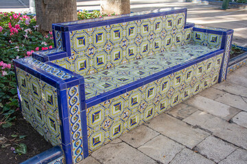Traditional blue ceramic tile bench in a park in Elche, Alicante, Spain