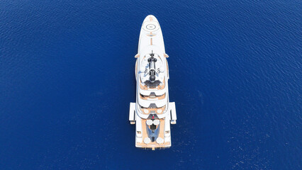 Aerial drone top down photo of luxury yacht with wooden deck anchored in paradise exotic deep blue sea island bay © aerial-drone