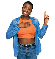 Young african american woman wearing casual clothes smiling swearing with hand on chest and fingers...