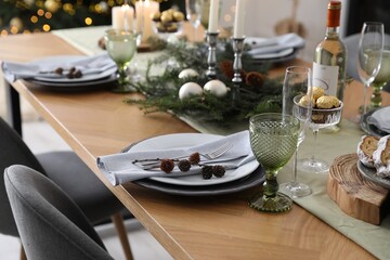 Christmas table setting with festive decor and dishware indoors