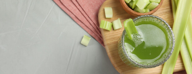 Delicious celery juice and fresh stems on grey table, top view. Banner design with space for text