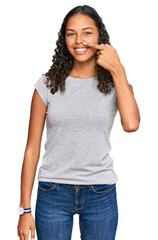 Fototapeta premium Young african american girl wearing casual clothes pointing with hand finger to face and nose, smiling cheerful. beauty concept
