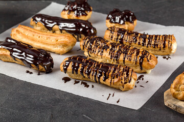 A pastry chef decorates ready-made eclairs with chocolate as they are being made