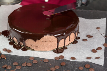Cake decoration. Chocolate glaze. Chef decorated pie. Confectioner smears liquid chocolate glaze. Homemade baking concept