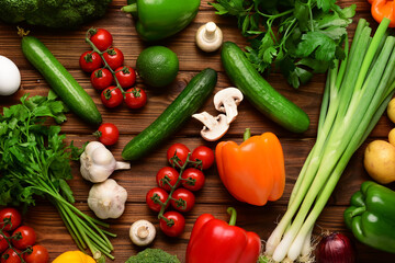 Fresh vegetables, greenery and mushrooms on wooden background