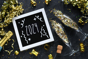 Happy New Year 2024 - gold confetti and champagne sparkling wine glasses