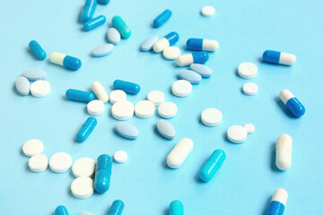 Many different pills on blue background