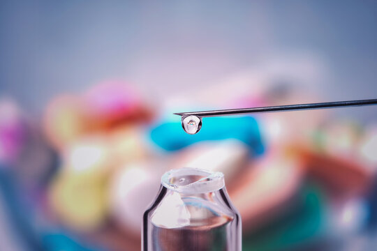 Liquid drop on the tip of a medical needle , bright colorful background , macro photography , medical concept , medical concept - Powered by Adobe