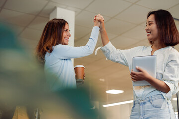 Diverse business woman giving each other high five during a meeting