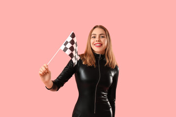Happy young woman with racing flag on pink background