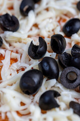 pizza dough with cheese and meat and olives