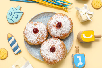 Composition with tasty donuts, gifts and decor for Hanukkah celebration on color background