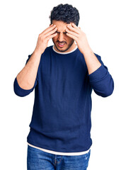 Young hispanic man wearing casual clothes with hand on head for pain in head because stress. suffering migraine.