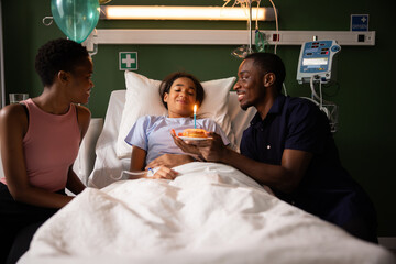 Parents create a cheerful atmosphere in the hospital room with a mini-party. Celebrating daughter...