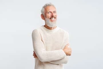 Handsome happy mature man, gray haired bearded hipster wearing stylish sweater holding arms crossed, hugging himself looking at camera isolated on white background