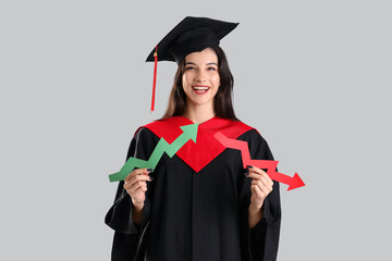Female graduate student with arrows on light background. Price rise concept