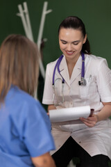 Young female doctor discusses results with senior patient in hospital.