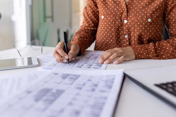 Close-up of hands of a woman working in the office at the table, signing business papers, working...