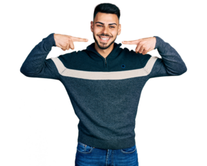 Young hispanic man with beard wearing casual winter sweater smiling cheerful showing and pointing with fingers teeth and mouth. dental health concept.