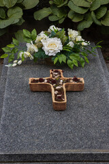 Grab mit Pflanzschale und  künstlichen weißen Trauerblumen