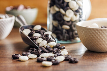 Sweet breakfast cereals in scoop on kitchen table.