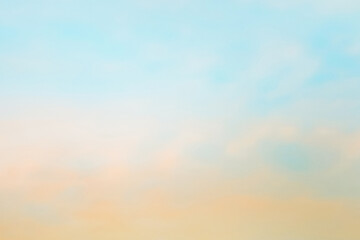 Twilight sky with effect of light in pastel pink, coral, orange, blue tones. Colorful sunset of soft clouds. Background